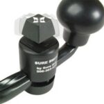 Close-up of a black Sure Switch device with a rotating knob and attached cables, used for controlling electronic equipment.