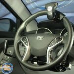 A Hyundai car steering wheel fitted with adaptive driving aids, including a spinner knob and hand control lever, designed to assist drivers with limited mobility. The logo Leisure Grip is visible in the bottom left corner.