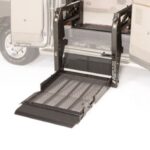 A wheelchair lift is extended from the side of a vehicle, providing a ramp for easy access to the interior.