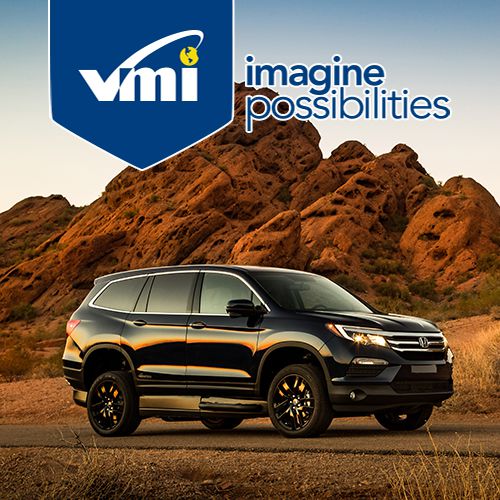 A black SUV parked on a desert road with rocky hills in the background. The VMI logo and the phrase imagine possibilities appear at the top of the image.