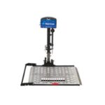 A vertical wheelchair platform lift with a blue motor housing, black support structure, and a metal platform with a perforated surface for accessibility.