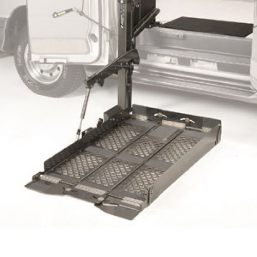 A metal wheelchair lift extended from the side of a van, with a textured platform and safety rails, designed to assist individuals in entering or exiting the vehicle.