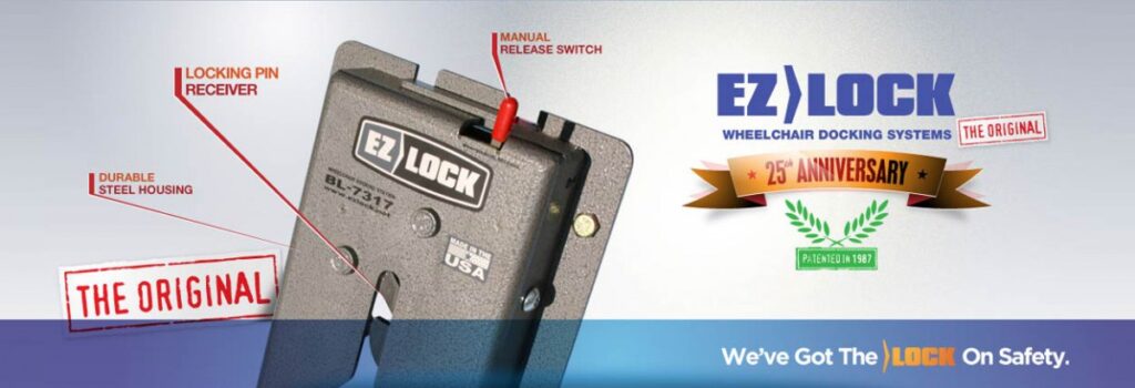 Close-up of an EZ Lock wheelchair docking system with labeled parts, including locking pin receiver, manual release switch, and durable steel housing. A banner marks the 25th anniversary and states, “We’ve Got The Lock On Safety.”.