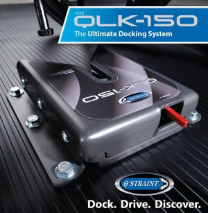 A close-up of the QLK-150 docking system by Q’STRAINT, mounted on a grooved surface, with bold text reading The Ultimate Docking System and Dock. Drive. Discover. in the image corners.